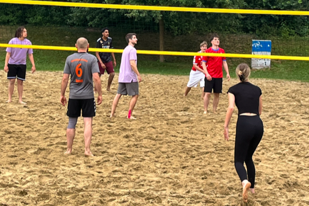 Schüler und Lehrkräfte beim Volleyball-Spiel